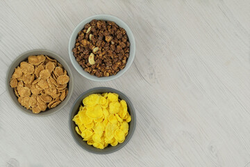 Breakfast cereals in bowls on a light wooden background. Fast food. Space for text. Top view.