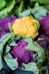 Colorful yellow and purple cauliflowers in natura on a gray surface © Luca
