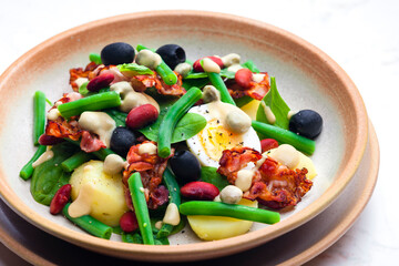 salad of green and red beans with black olives, spinach, boiled egg and bacon