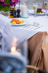 Salmon steak and white wine on table,Seared salmon fillet with wine on restaurant background,Delicious salmon steak with three kinds of sauces served on blue plate on wooden table in restaurant. Glass