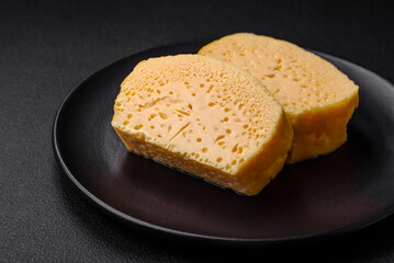 Delicious porous yellow cheese cut in large pieces on a ceramic plate