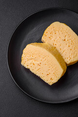 Delicious porous yellow cheese cut in large pieces on a ceramic plate