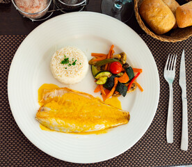 Delicious sea bass fillet with curry sauce, basmati rice and vegetables