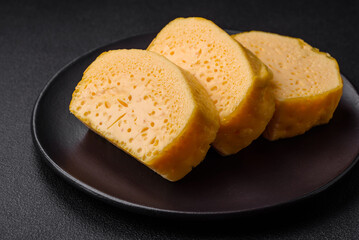 Delicious porous yellow cheese cut in large pieces on a ceramic plate