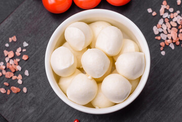 Delicious fresh mozzarella cheese in the form of small balls with salt and spices