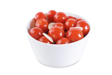 Pickled tomatoes in a bowl with garlic on a white isolated background