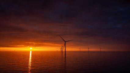 Sunset offshore at wind turbine farm