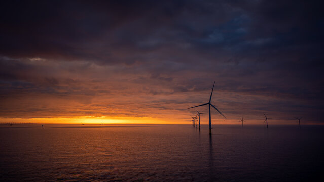Sunset offshore at wind turbine farm