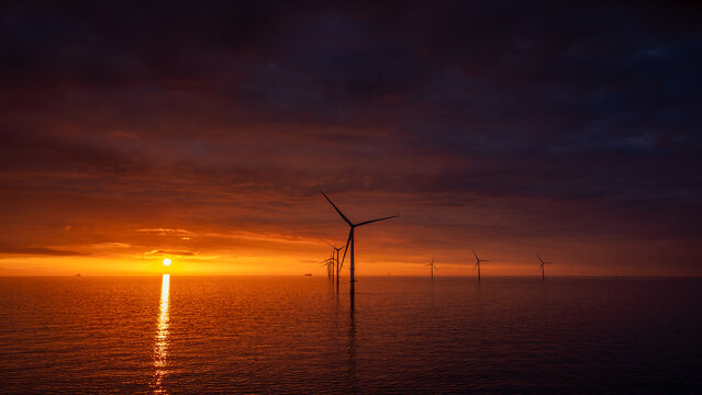 Sunset offshore at wind turbine farm