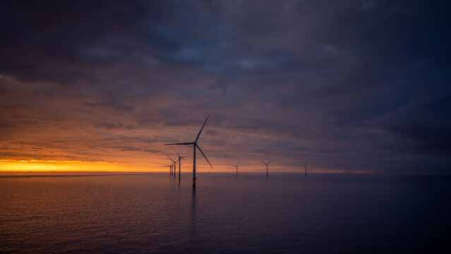 Sunset offshore at wind turbine farm