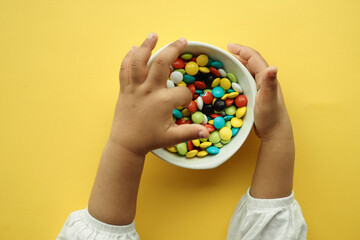 Fototapeta na wymiar child hand pick colorful candy sweet jelly 
