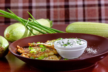 Baked vegetable pancakes with pumpkin and zucchini, served with sour cream dip