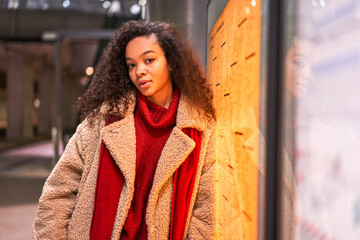 Multiracial cute woman standing at the metro station tunnel and waiting transport