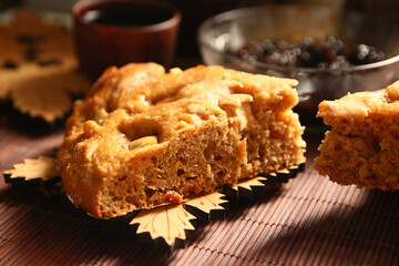 Homemade apple pie, tea, wooden necklace and jam from cones on the table.