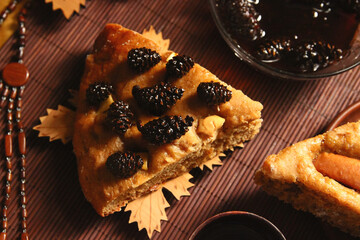 Homemade apple pie, tea, wooden necklace and jam from cones on the table.
