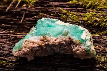 Sample of raw bright green chrysoprase lying on wood, Kazakhstan deposit