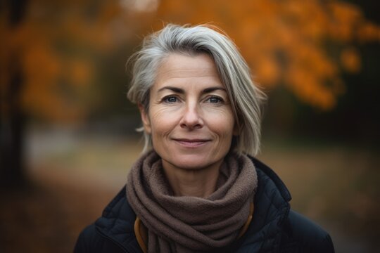 Headshot portrait photography of a pleased woman in her 40s wearing a cozy sweater against an autumn foliage background. Generative AI