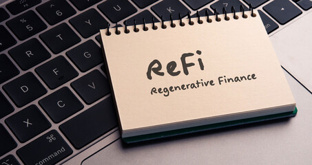 There is notebook with the word ReFi  Regenerative Finance.It is as an eye-catching image.