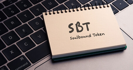 There is notebook with the word Soulbound Token (SBT).It is as an eye-catching image.
