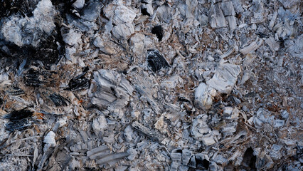 Gray ash from the oven background texture, cinder, grey ashes from the wood from the fireplace. Smoldering embers.