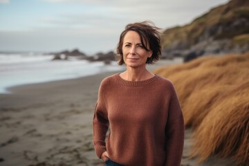 Fototapeta na wymiar Portrait of a beautiful mature woman standing on the beach at sunset