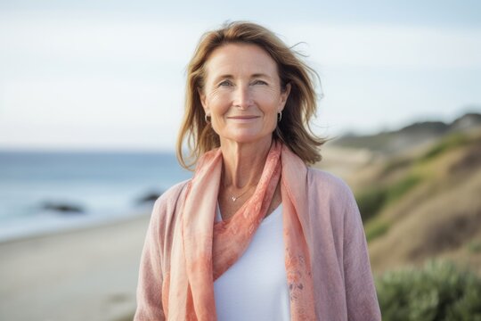Lifestyle portrait photography of a pleased woman in her 40s wearing a chic cardigan against a summer landscape or beach background. Generative AI