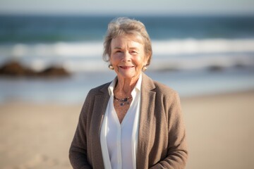 Fototapeta na wymiar Portrait of happy senior woman standing on the beach at the day time