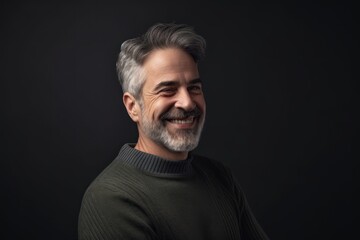 Portrait of a smiling senior man on a dark background. Copy space.
