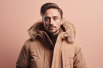 Portrait of a handsome young man in a jacket on a pink background