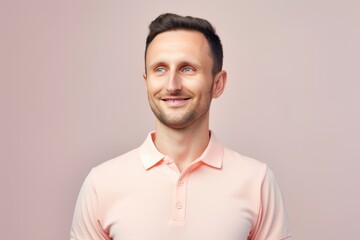 Portrait of a happy young man looking at camera on pink background