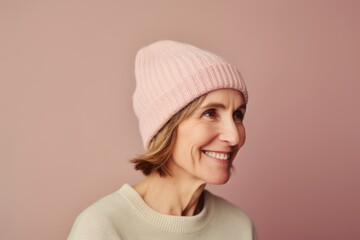 Portrait of smiling mature woman in pink hat and sweater looking at camera