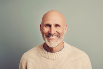 Obraz premium Portrait of a smiling mature man in a beige sweater.