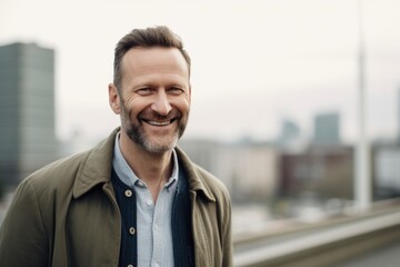 Fototapeta premium Portrait of handsome smiling man standing in the city. Business concept