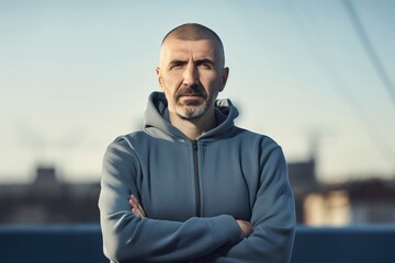 Fototapeta premium Portrait of a man in a hooded jacket on the background of the city