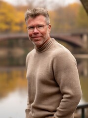 Portrait of a middle-aged man in a sweater on a background of autumn nature.