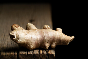 Ginger root and powder on a rustic wood, close-up image