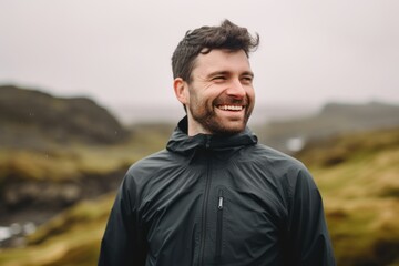 Portrait of a smiling man in a raincoat on the beach