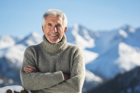 Portrait of happy senior man with arms crossed against snowy mountain landscape