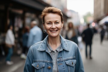 Portrait of a beautiful middle-aged woman in a denim jacket on the street