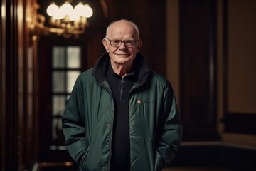 Portrait of a smiling senior man in a green jacket and glasses.