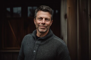 Obraz premium Portrait of a handsome man in a gray sweater on a wooden background