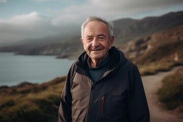 Portrait of a smiling senior man standing on a mountain trail.