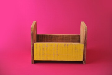 caixa de madeira com amarelo em fundo rosa 