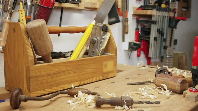 closeup view of the carpenter's wooden table full of woodworking tools in the workshop. High quality 4k footage