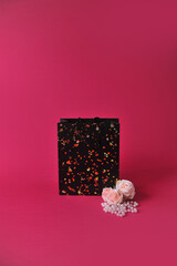 Conceito de presente de dia das mães. uma bolsa da moda preta   em um fundo rosa com espaço vazio para texto ou anúncio