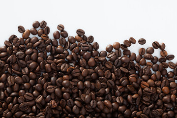 Closeup of roasted coffee beans on white background..