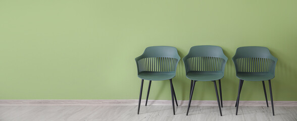Chairs near green wall in room. Banner for design