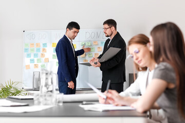 Male colleagues working on business plan in office