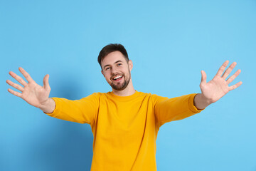 Man giving high five on light blue background