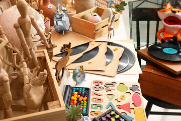 Many different items on white table indoors. Garage sale